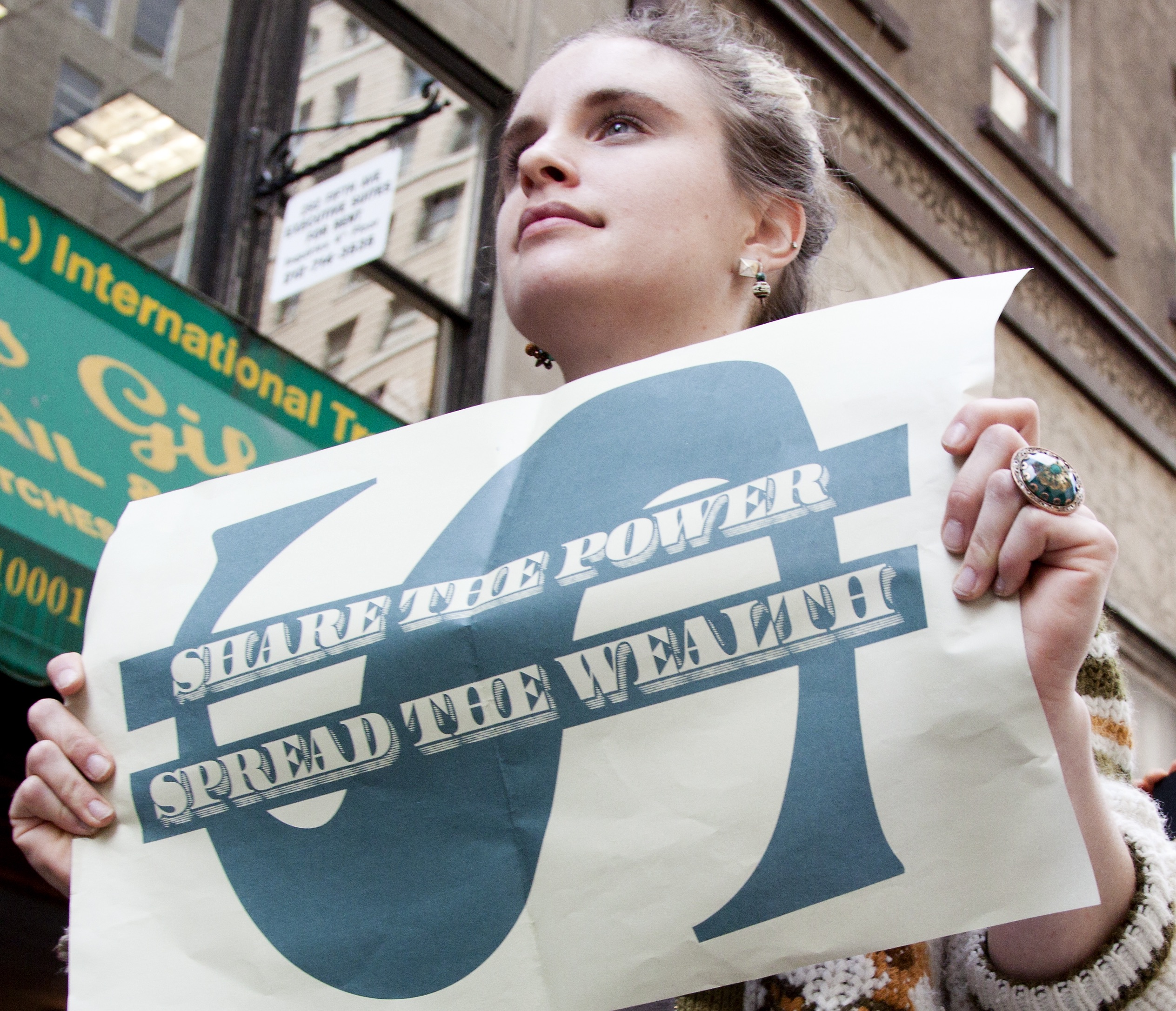 Woman holds protest sign about inequality